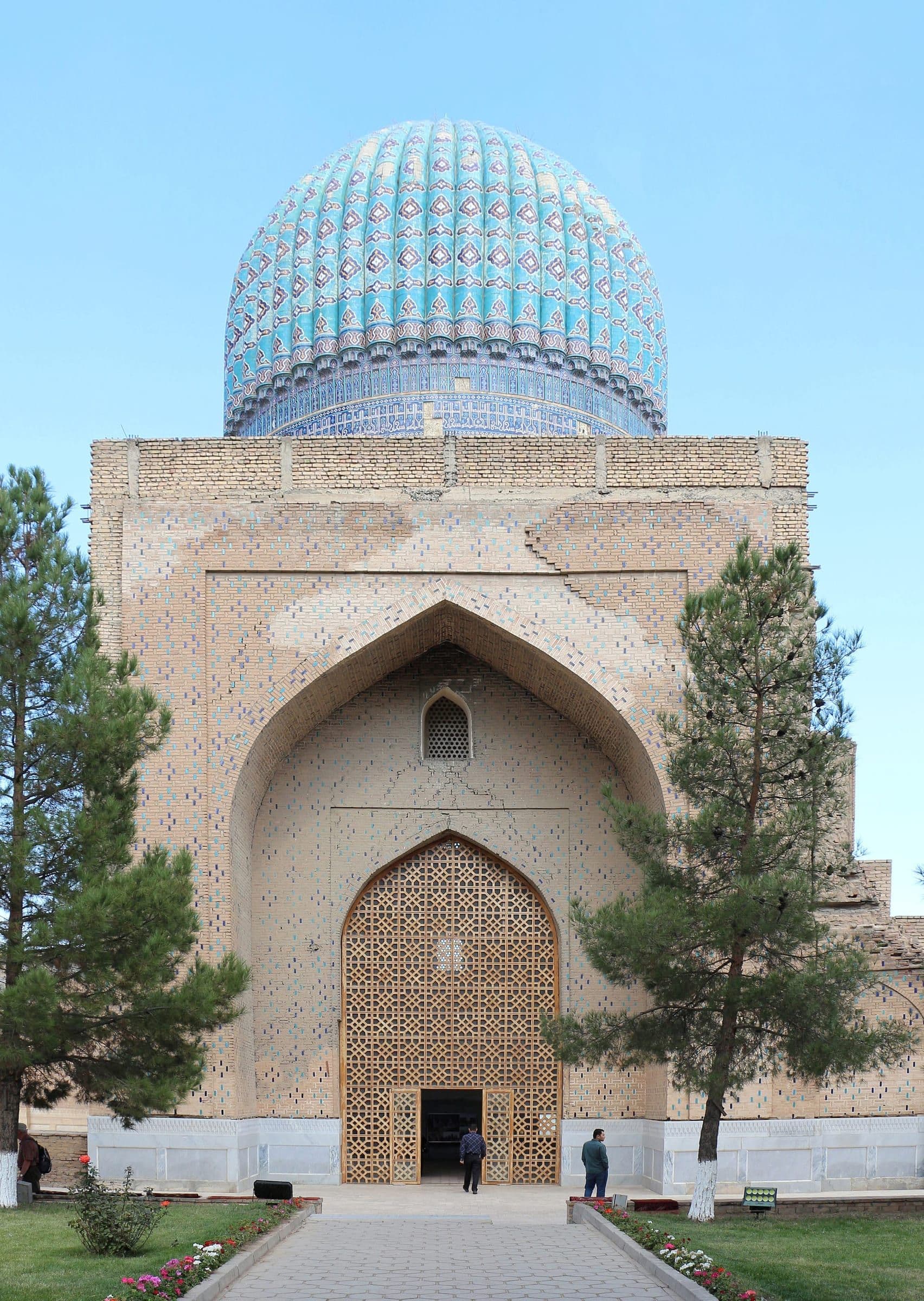 Bibi-Khanym, Samarkand: a ribbed turquoise dome rises over a brick portal with a geometric wooden lattice entrance