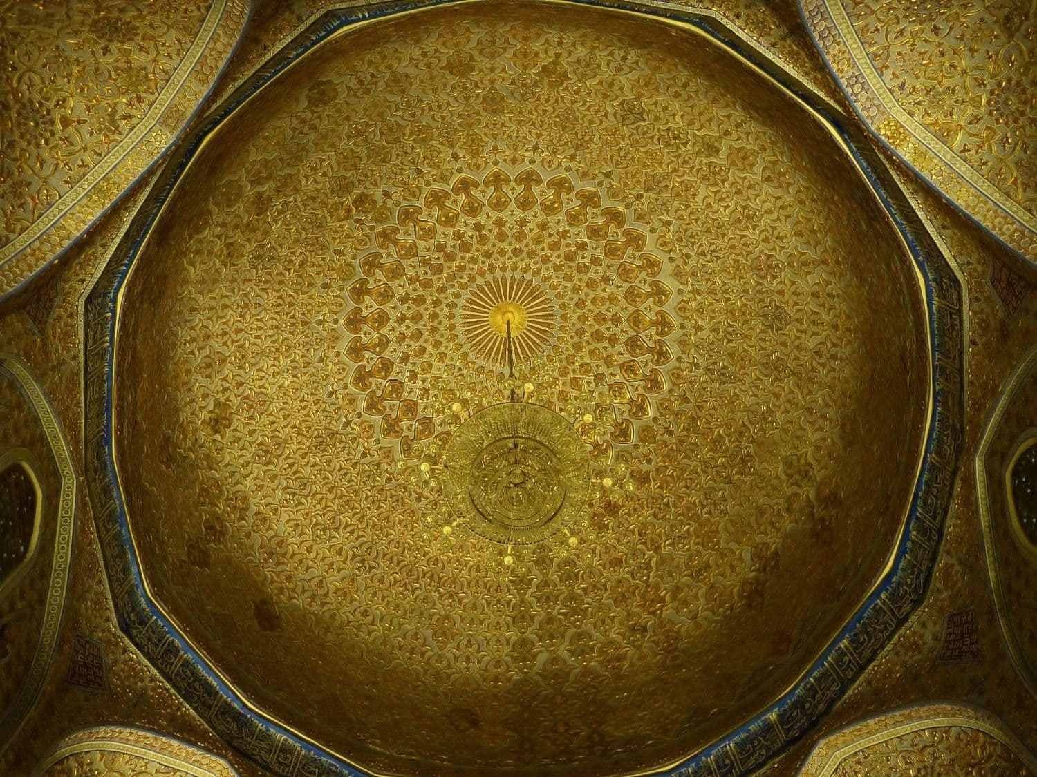 Inside Gur-e-Amir, Samarkand: the gilded inner dome, covered in relief patterns, with a gold chandelier at its centre