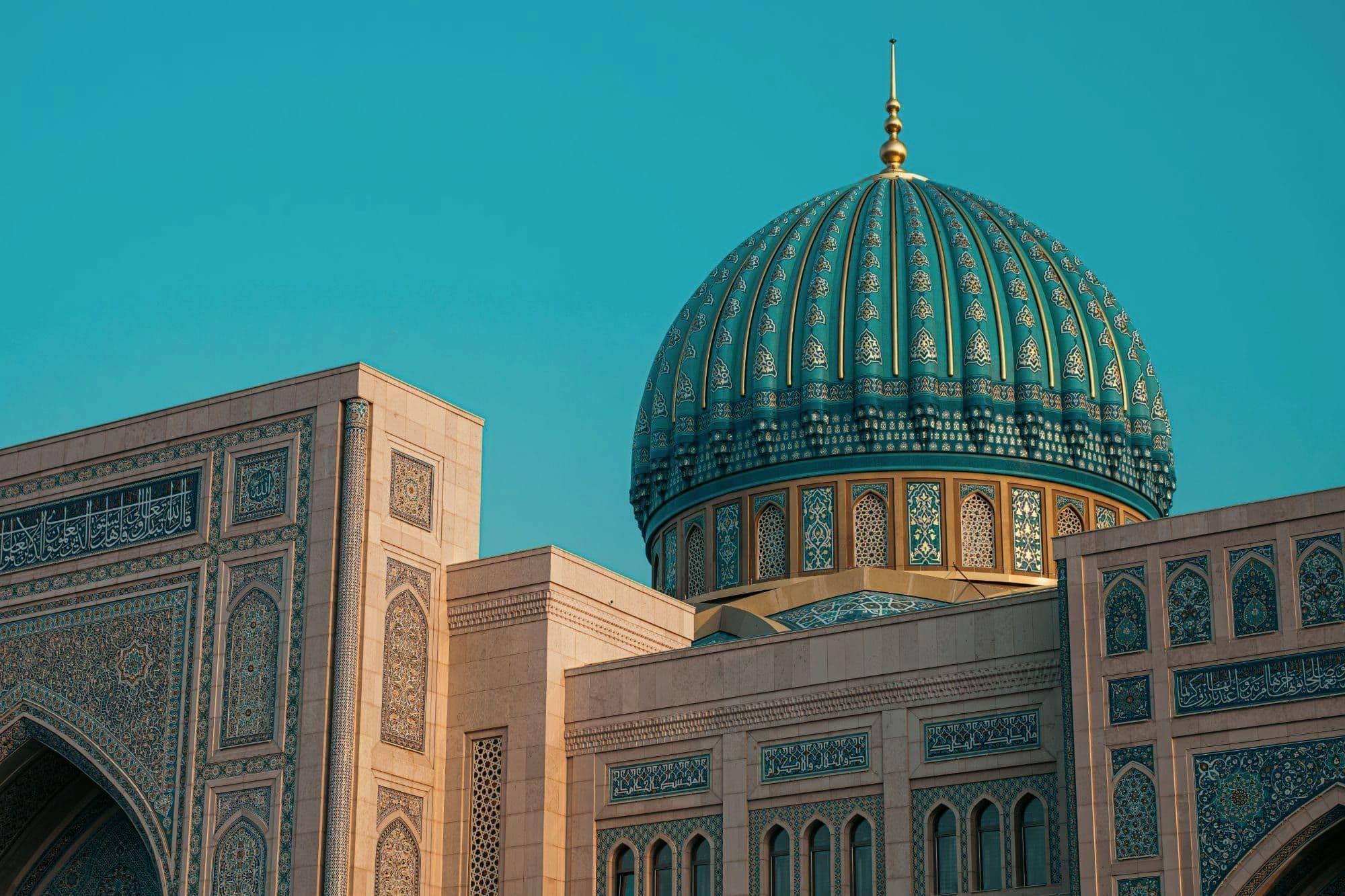 Gold-ribbed turquoise dome above the tiled, calligraphy-framed walls of Tashkent's Centre of Islamic Civilization